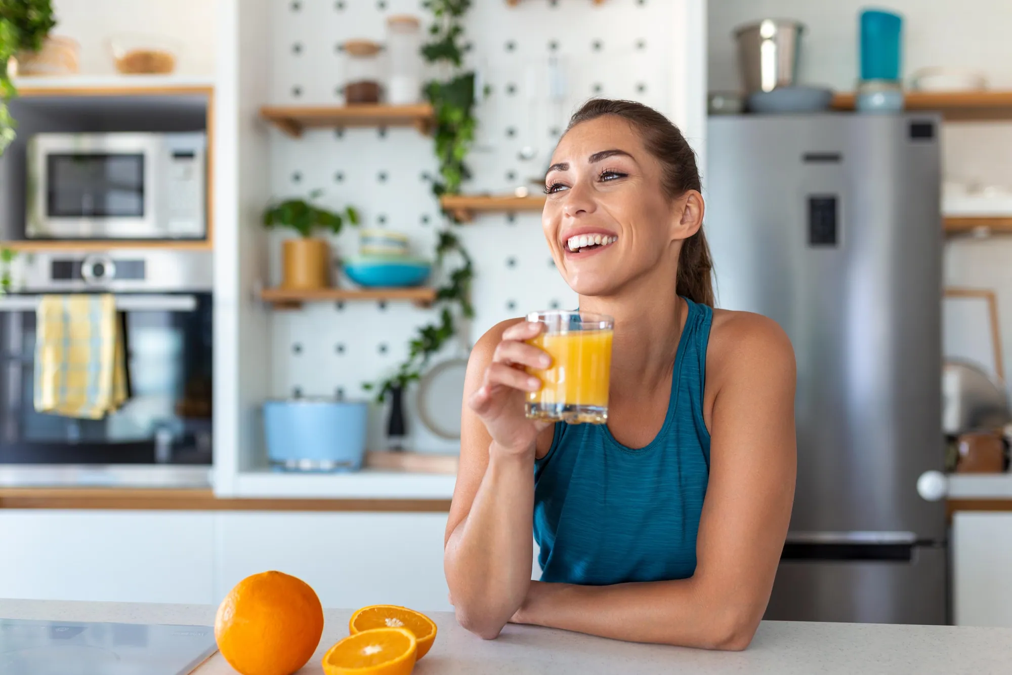 A Eurolux electric citrus press filling a glass, oranges beside it